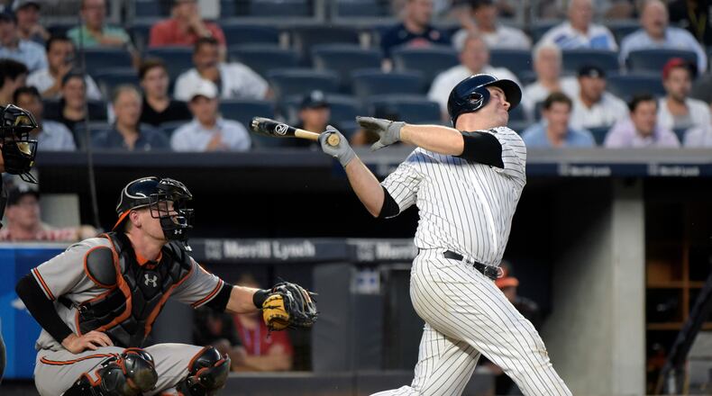 New York Yankees' Brian McCann, right, hits a sacrifice fly scoring Brett Grdner as Baltimore Orioles catcher Matt Wieters looks on during the third inning of a baseball game Monday, July 18, 2016, at Yankee Stadium in New York. The Yankees won 2-1. (AP Photo/Bill Kostroun)