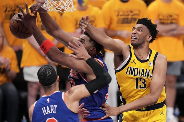New York Knicks center Karl-Anthony Towns, middle, reaches for the ball in front of Indiana Pacers center Tony Bradley (13) during the second half of Game 3 of the Eastern Conference finals of the NBA basketball playoffs Sunday, May 25, 2025, in Indianapolis. (AP Photo/AJ Mast)