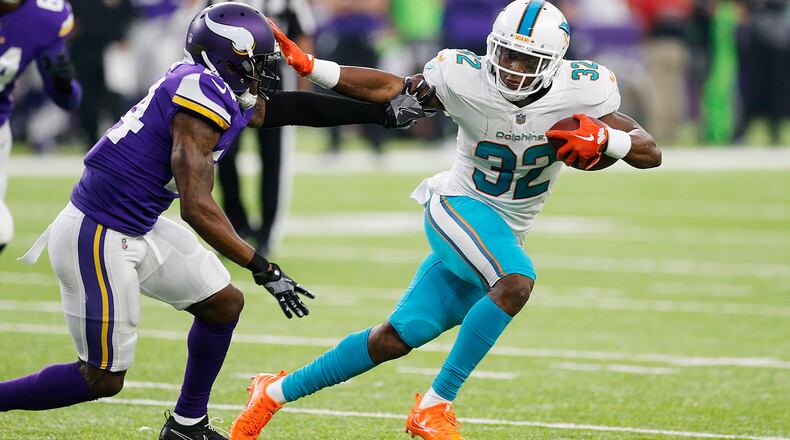 Miami Dolphins running back Kenyan Drake breaks a tackle by Minnesota Vikings cornerback Jabari Price, left, during the first half of an NFL preseason football game, Thursday, Aug. 31, 2017, in Minneapolis. (AP Photo/Jim Mone)