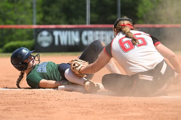 Cherokee’s Kayleigh Parton (right) tags out Creekview’s Makinley Foster at third base during a GHSA championship slow-pitch softball game Thursday, April 23, 2026, at Twin Creeks Softball Complex in Woodstock. (Daniel Varnado for the AJC)