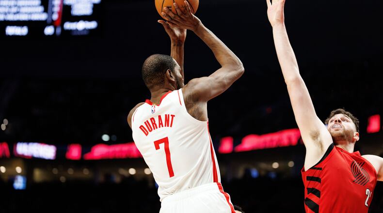 Houston Rockets forward Kevin Durant, left, shoots over Portland Trail Blazers center Donovan Clingan, right, during the second half of an NBA basketball game Friday, Jan. 9, 2026, in Portland, Ore. (AP Photo/Howard Lao)