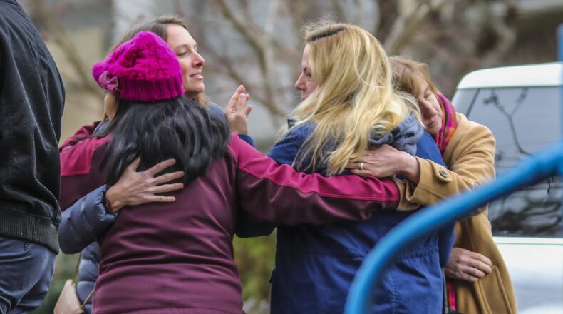 Parents hug one another upset after Montgomery Elementary School was on lockdown Thursday morning because of a bomb threat. Dunwoody High School and Chesnut, Dunwoody, and Vanderlyn elementary schools also received threats, which police said turned out not to be credible. JOHN SPINK/JSPINK@AJC.COM