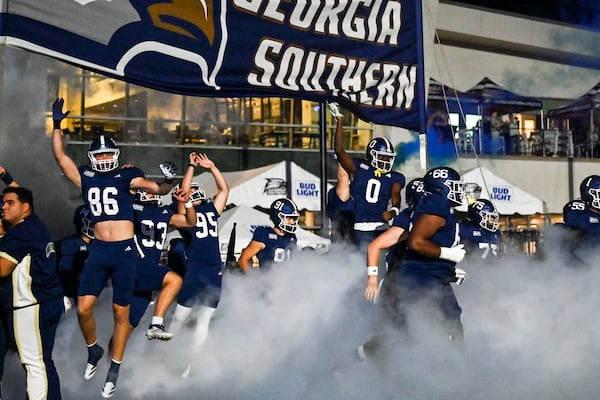 Georgia Southern University football players run onto the field before the game against the University of Southern Mississippi on Oct. 9 in Statesboro. (Sarah Peacock for the AJC)