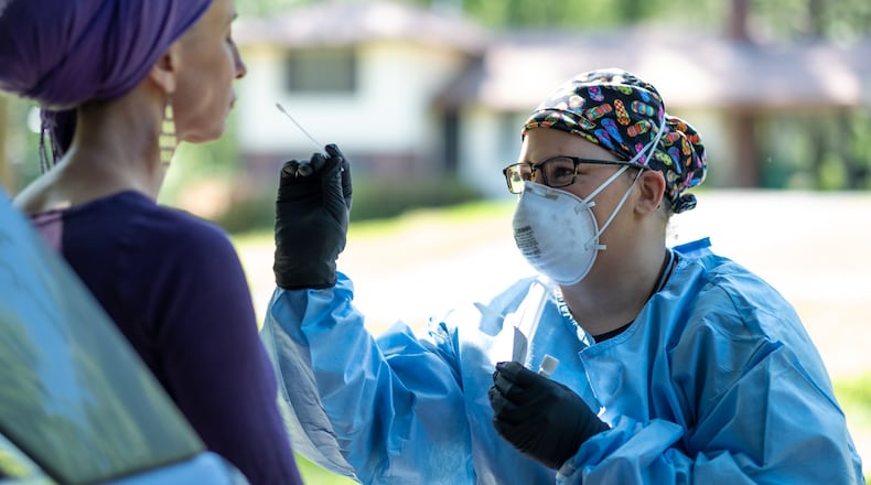 Free mobile testing for COVID-19 are offered this week in Milton Sandy Springs and Roswell. The three cities saw some increase in new cases from Aug. 21-Sept. 4, according to a Fulton County Department of Health report. Pictured, Adrienne Clark, a registered nurse and founder of Qualified Quacks, a medical house call service, gave her neighbor Rachel Welfeld a coronavirus in April. Welfeld recovered from Covid-19 and was being tested to be sure she was no longer positive. Ben@BenGray.com for the Atlanta Journal-Constitution