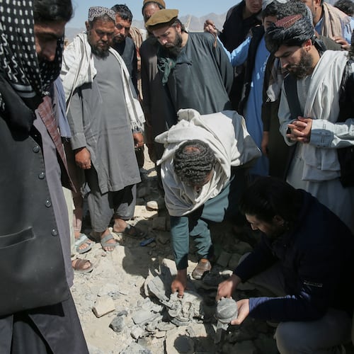 Residents and Taliban police gather the remains of a projectile at the site of a strike in Kabul, Afghanistan, Friday, March 13, 2026. (AP Photo/Barackatullah Popal)