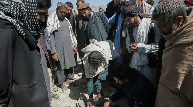 Residents and Taliban police gather the remains of a projectile at the site of a strike in Kabul, Afghanistan, Friday, March 13, 2026. (AP Photo/Barackatullah Popal)