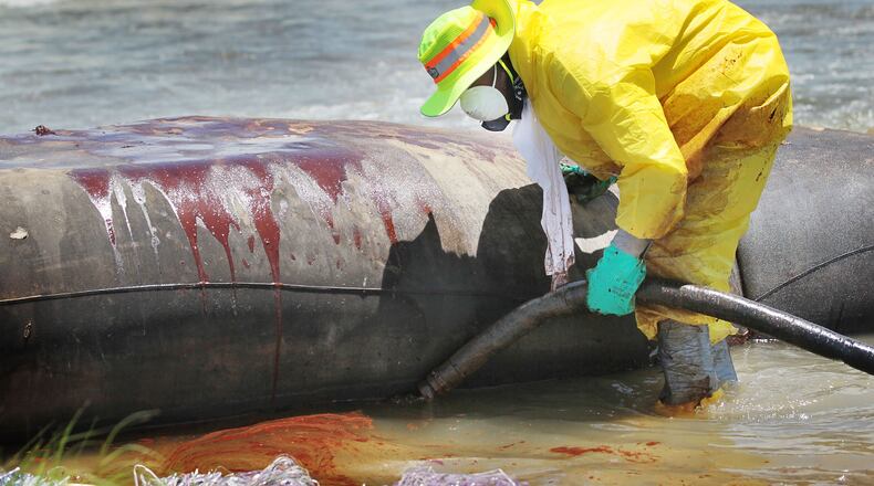 A worker uses a vacuum hose to capture some of the oil washing on to Fourchon Beach from the Deepwater Horizon oil spill in the Gulf of Mexico on June 28, 2010 in Port Fourchon, Louisiana. According to reports on June 28, analysts are saying the economic damage from the oil may not impact the U.S. economy beyond the Gulf region. Millions of gallons of oil have spilled into the Gulf since the April 20 explosion on the drilling platform. (Photo by Joe Raedle/Getty Images)