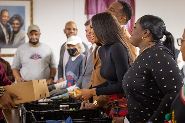 Ciara (center) gives out food at Saint Peter Missionary Baptist Church in Atlanta on Tuesday, Dec 23, 2025. She said, "No child deserves to go to bed hungry." (Arvin Temkar/AJC)