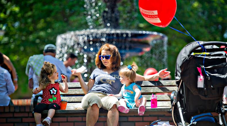 Tammy Shiflett (center) eats a snack with her granddaughter Lowery Collins (left) and niece Claire Shiflett as they sit on a bench during the May-retta Daze Arts & Craft Festival at Glover Park in Marietta on Sunday, May 4, 2014.