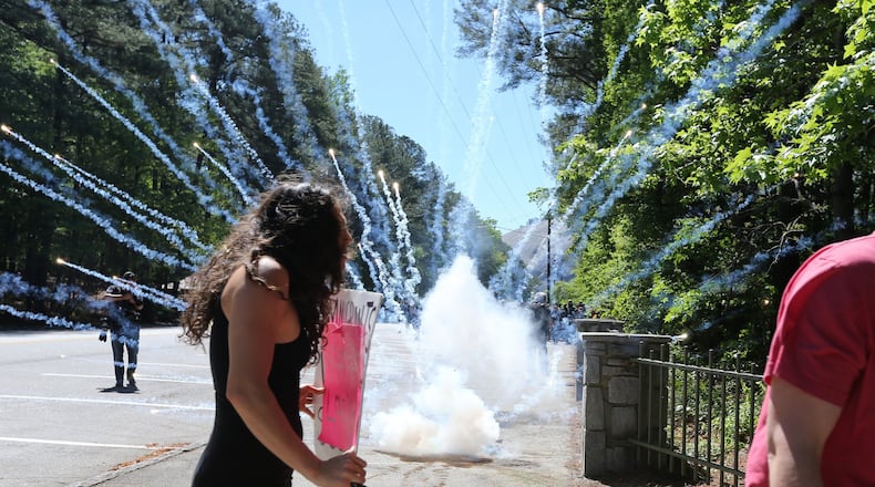 Fireworks explode as counter-protesters clash with police at Stone Mountain Park Saturday. Ben Gray / bgray@ajc.com