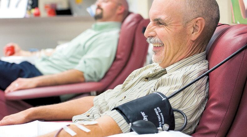 Jeremy Wilcox, in background, and Jerry Wilcox catch up with each other’s family news while they donate blood in Orange, California, on July 23, 2013. They coordinate their schedules and regularly donate blood at the same time, a tradition they’ve kept since 2006. (H. Lorren Au Jr./Orange County Register/MCT)