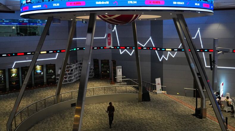 A man walks past an electronic board displaying stock prices and Jakarta Stock Exchange Composite Index, at the Indonesia Stock Exchange in Jakarta, Indonesia, Wednesday, Jan. 28, 2026. (AP Photo/Tatan Syuflana)