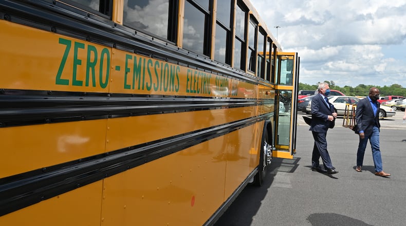 Blue Bird workers overwhelmingly approved their first union contract with the company this week, a bargain that bumps up retirement savingRs and provides profit-sharing for workers. The Fort Valley-based company is leaning hard into electric vehicles now, some of that subsidized by the federal government. Here, in 2021, Sen. Raphael Warnock (right) and Phil Horlock, president and CEO, after a test ride on an electric school bus. (Hyosub Shin / Hyosub.Shin@ajc.com)