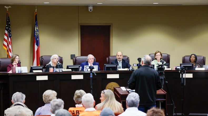Board members listen to a speaker during a State Election Board meeting at Dawson County Government Center on Wednesday, April 15, 2026. (Miguel Martinez/AJC)