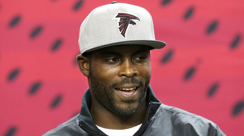 Former Atlanta Falcons quarterback Michael Vick sports a team hat as he returns to the Georgia Dome before the Falcons played the New Orleans Saints in an NFL football game Sunday, Jan. 1, 2017, in Atlanta. (Curtis Compton/Atlanta Journal-Constitution via AP)
