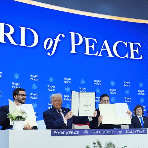 President Donald Trump, center, holds up a signed Board of Peace charter during the Annual Meeting of the World Economic Forum in Davos, Switzerland, Thursday, Jan. 22, 2026. (AP Photo/Evan Vucci)