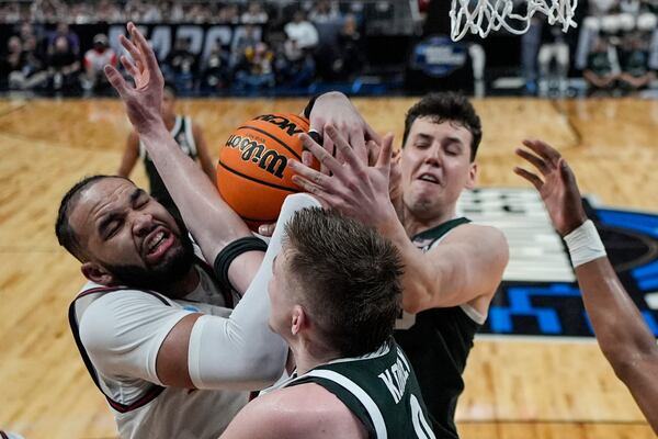 Auburn forward Johni Broome (4) and Michigan State center Szymon Zapala (10) work for a rebound during the first half in the Elite Eight of the NCAA college basketball tournament, Sunday, March 30, 2025, in Atlanta. (AP Photo/Brynn Anderson)