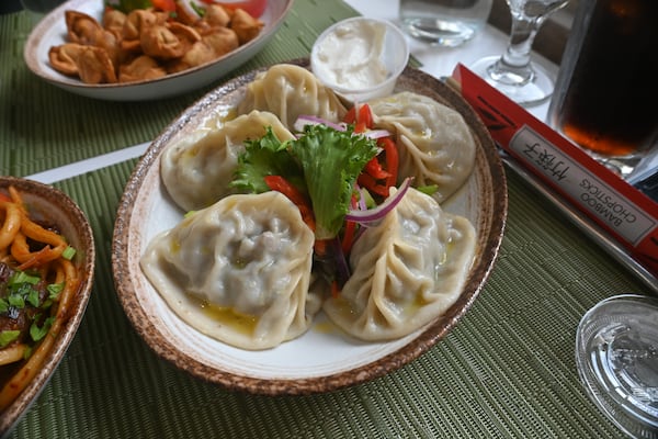 A large order of manti stuffed with minced lamb and onion, served with a cup of tangy cup of yogurt sauce with lettuce garnish.