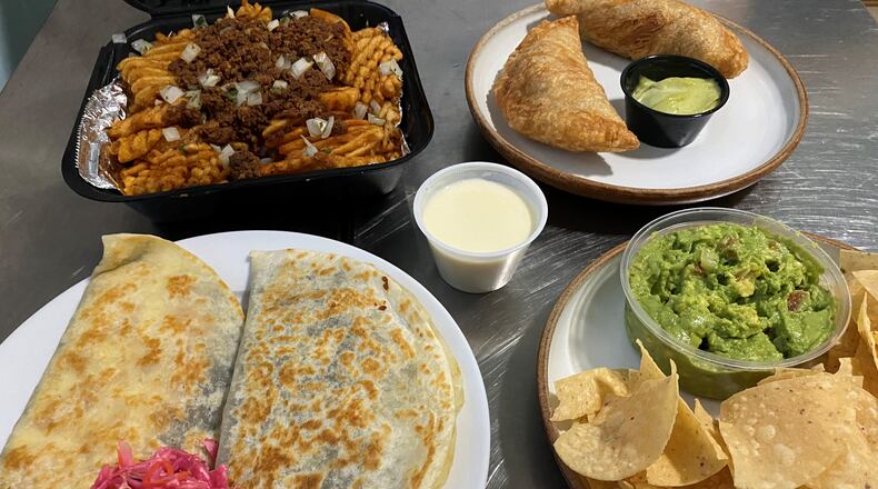 Takeout from Lean Draft House in southwest Atlanta: Top: chorizo fries and empanadas stuffed with carnitas. Bottom: a baleada (a Honduran specialty similar to a quesadilla; this one is stuffed with fried grouper); and guacamole and chips.
Wendell Brock for The Atlanta Journal-Constitution