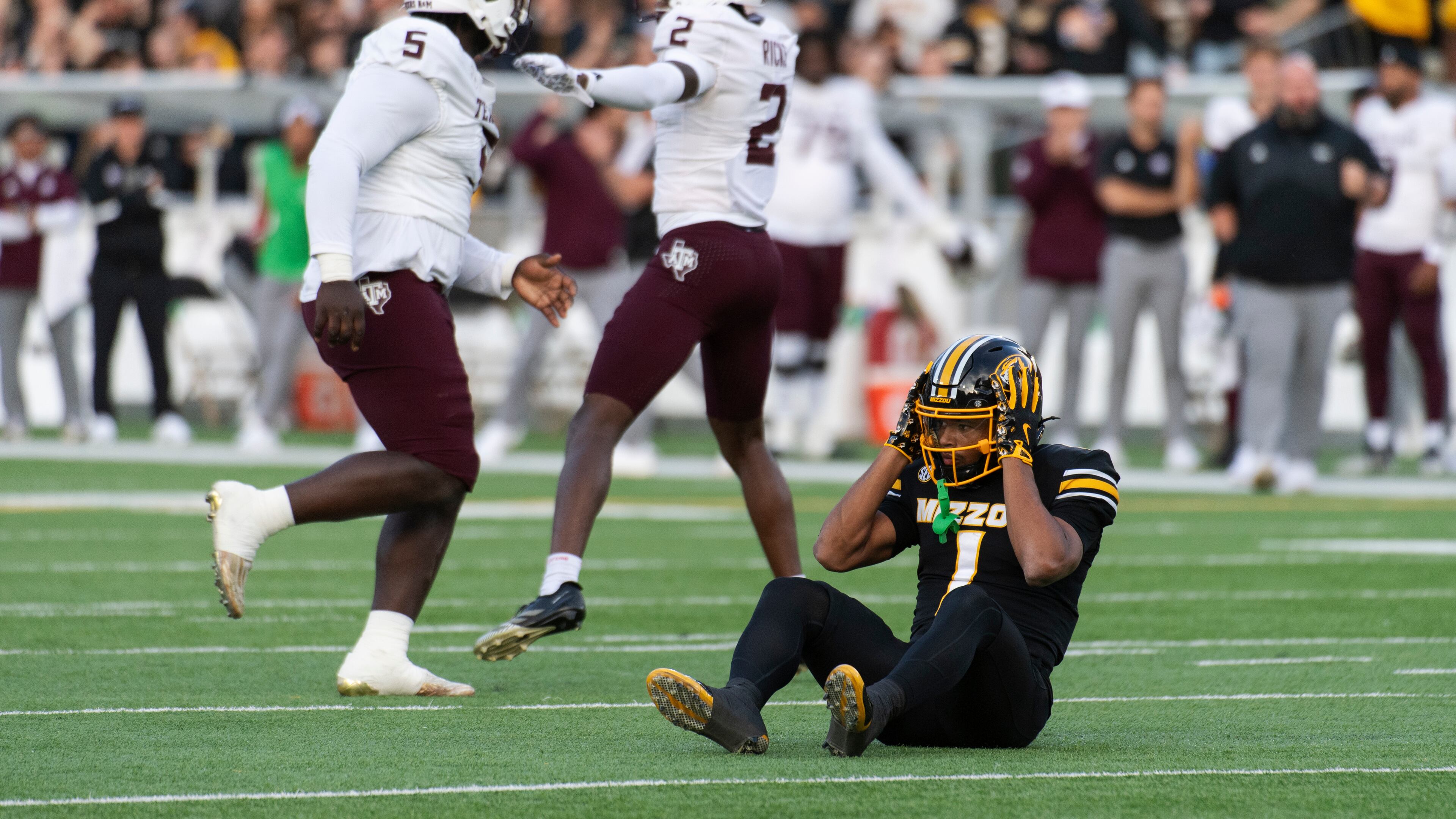 Missouri wide receiver Donovan Olugbode (1) grabs his helmet after missing a fourth-down reception as Texas A&M defensive tackle DJ Hicks (5) and cornerback Dezz Ricks (2) celebrate during the first half an NCAA college football game Saturday, Nov. 8, 2025, in Columbia, Mo. (AP Photo/L.G. Patterson)