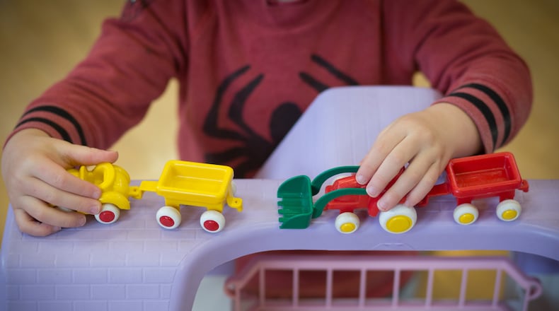 A young boy plays with toys at a playgroup for pre-school aged children.