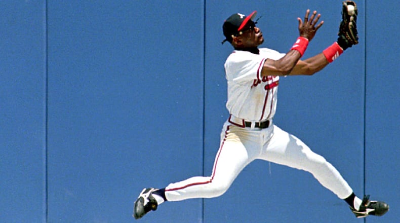Braves’ center fielder Marquis Grissom makes a catch at the warning track to rob Chicago Cubs’ third baseman Leo Gomez of a hit May 22, 1996.(AP Photo/Andrew Innerarity)