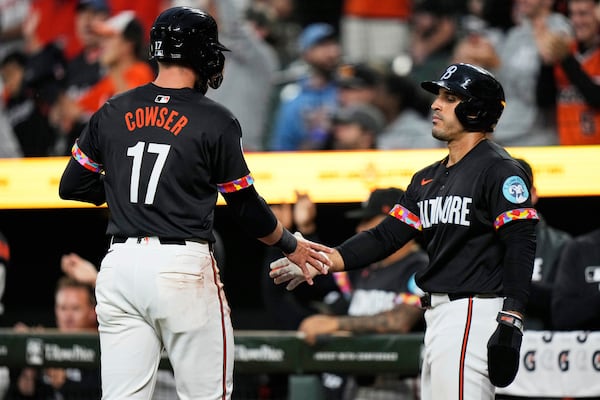 Baltimore Orioles' Colton Cowser (17) and Ramon Laureano, right, celebrate after scoring on a two-run RBI hit by Coby Mayo during the second inning of a baseball game, Friday, June 27, 2025, in Baltimore. (AP Photo/Stephanie Scarbrough)