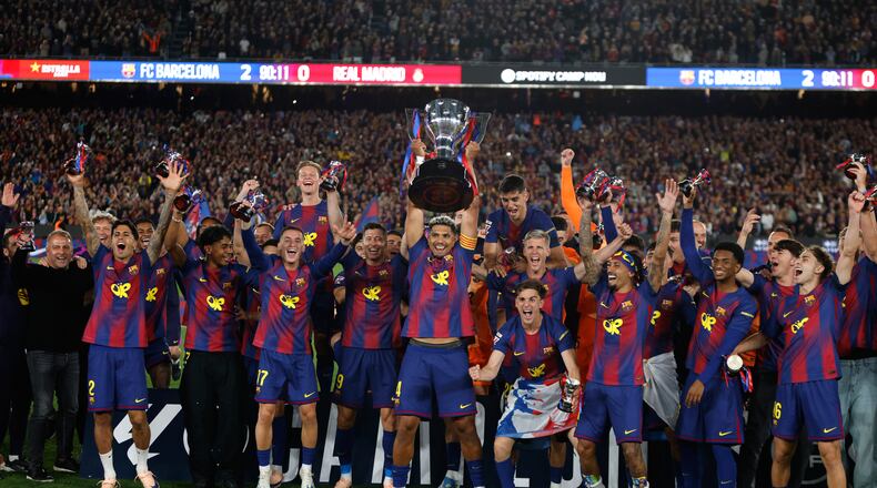 Barcelona players lift the trophy after winning the Spanish La Liga soccer match against Real Madrid to clinch the Spanish league title in Barcelona, Spain, Sunday, May 10, 2026. (AP Photo/Joan Monfort)