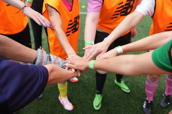 A team taps hands during an inclusive six a side soccer friendly tournament in London, Sunday, June 1, 2025. (AP Photo/Alastair Grant)