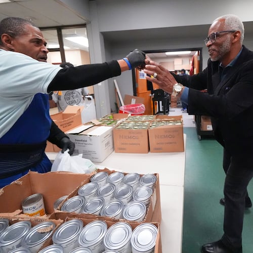 Richard Miles, right, founder and CEO of Miles of Freedom, a Dallas-based group that provides help for individuals after they have been released from prison, whether they are on parole or are exonerees, greets his organization's soup kitchen volunteer Frederick Briscoe on Tuesday, April 21, 2026 in Dallas. (AP Photo/Julio Cortez)