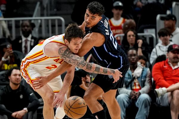 Atlanta Hawks guard Vit Krejci (27) and Orlando Magic forward Tristan da Silva (23) chase a loose ball during the first half of an NBA basketball game, Sunday, April 13, 2025, in Atlanta. (AP Photo/Mike Stewart)