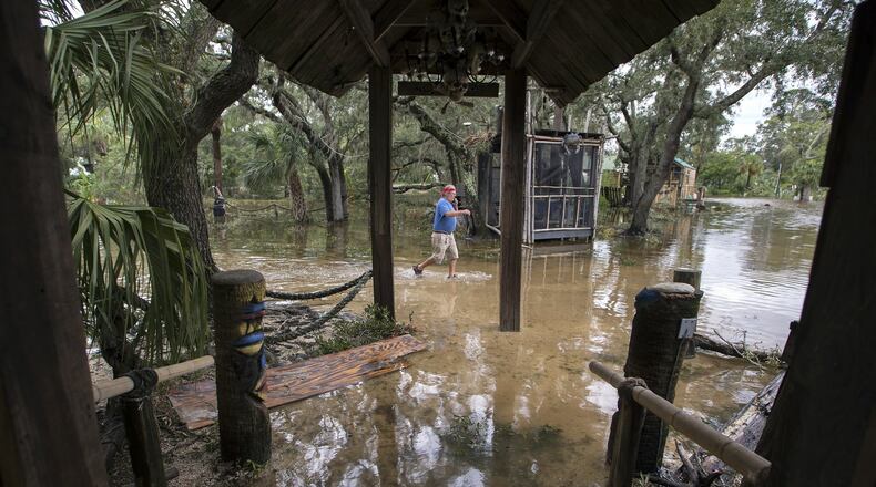 A Crab Shack restaurant employee walks through the business near Tybee Island, Ga., after winds and storm surge from Hurricane Matthew hit the small community along the east coast of Georgia, Saturday, Oct. 8, 2016. (AP Photo/Stephen B. Morton)