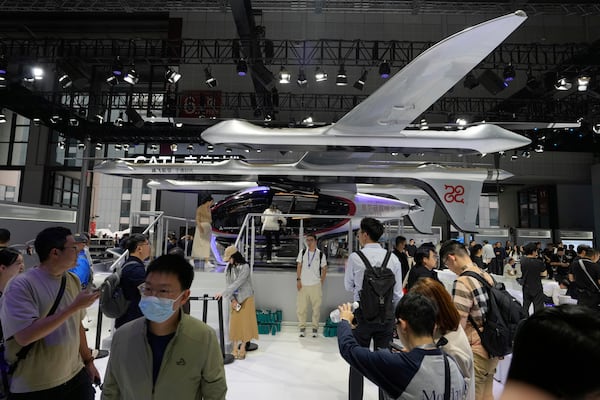 Visitors stand near a flying test platform from Chinese battery manufacturer CATL during the Shanghai auto show on Wednesday, April 23, 2025. (AP Photo/Ng Han Guan)