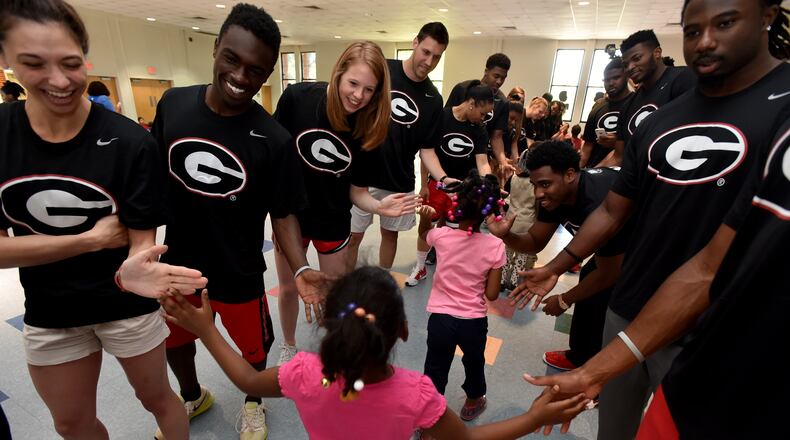 UGA student-athletes greet students as they enter the gym at D.H. Stanton Elementary School Wednesday May 6, 2015. Athletes representing 11 different sports, from the University of Georgia visited D.H Stanton Elementary School in Atlanta Wednesday as part of their annual UGA Day- Learn, Play, Excel initiative. The visit marks the fifth consecutive year UGA has partnered with an metro Atlanta area school. The student-athletes talked to the K -5th grade students about the importance of education, respecting authority, anti-bullying, perseverance and the pursuit of their dreams. Each student received a backpack, T-shirt and UGA poster following the event. BRANT SANDERLIN/BSANDERLIN@AJC.COM