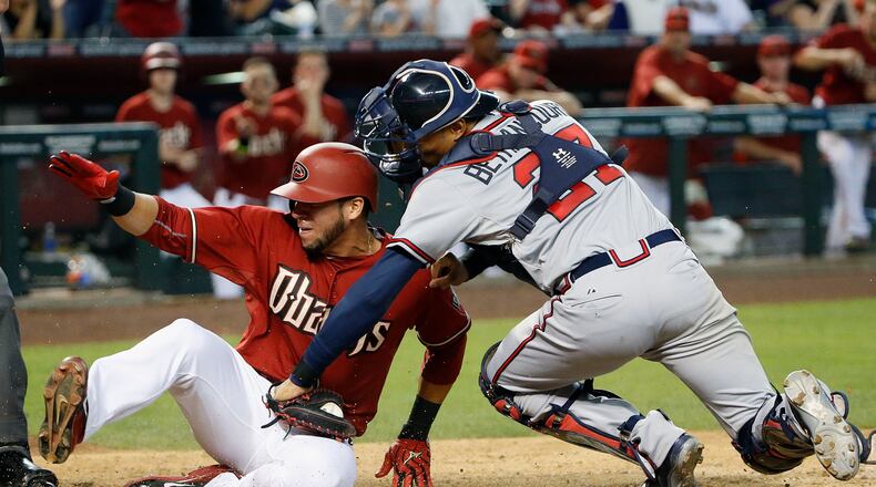Arizona Diamondbacks’ David Peralta, left, scores a run ahead of the tag by Atlanta Braves’ Christian Bethancourt, right, during the seventh inning of a baseball game Wednesday, June 3, 2015, in Phoenix. (AP Photo/Ross D. Franklin)