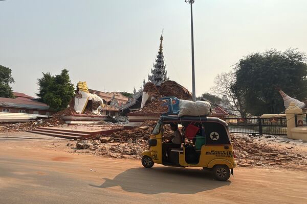 A local man drives past Maharmyatmuni pagoda in the aftermath of an earthquake, in Mandalay, central Myanmar, Sunday, March 30, 2025. (AP Photo/Thein Zaw)