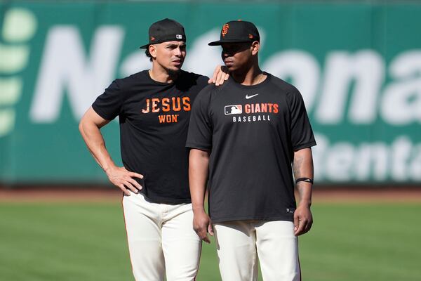 San Francisco Giants' Willy Adames, left, and Rafael Devers stand on the field while warming up before a baseball game against the Boston Red Sox in San Francisco, Friday, June 20, 2025. (AP Photo/Jeff Chiu)