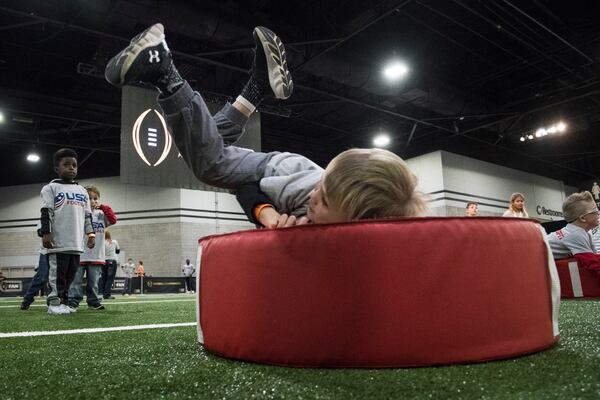 Fans including 5 year old Luke Collins of Fayetteville, Ga., participate at Fan Central in the World Congress Center during College Football Playoff National Championship festivities before the game to be held on January 8, pictured Saturday, Jan. 6, 2017, in Atlanta. More than 100,000 visitors expected for the game and related events over the weekend. (John Amis)