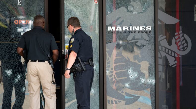 Police officers enter the Armed Forces Career Center through a bullet-riddled door after a gunman opened fire on the building Thursday in Chattanooga. (AP Photo / John Bazemore)