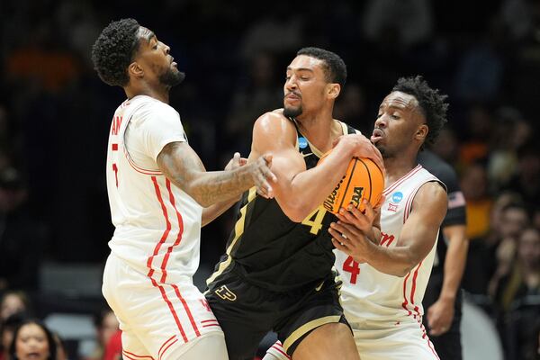 Purdue's Trey Kaufman-Renn, center, holds the ball as Houston's L.J. Cryer, right, and Ja'Vier Francis defend during the first half in the Sweet 16 of the NCAA college basketball tournament Friday, March 28, 2025, in Indianapolis. (AP Photo/Michael Conroy)