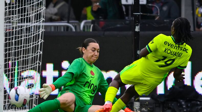 Washington Spirit forward Rosemonde Kouassi (19) plays the ball past Portland Thorns FC goalkeeper Mackenzie Arnold where teammate Gift Monday scored a goal during the first half of a NWSL semifinal women's soccer match, Saturday, Nov. 15, 2025, in Washington. (AP Photo/John McDonnell)