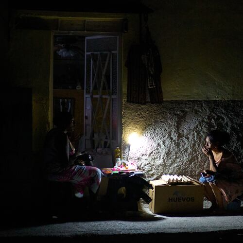 Street vendors chat during a blackout in Havana, Monday, March 16, 2026. (AP Photo/Ramon Espinosa)