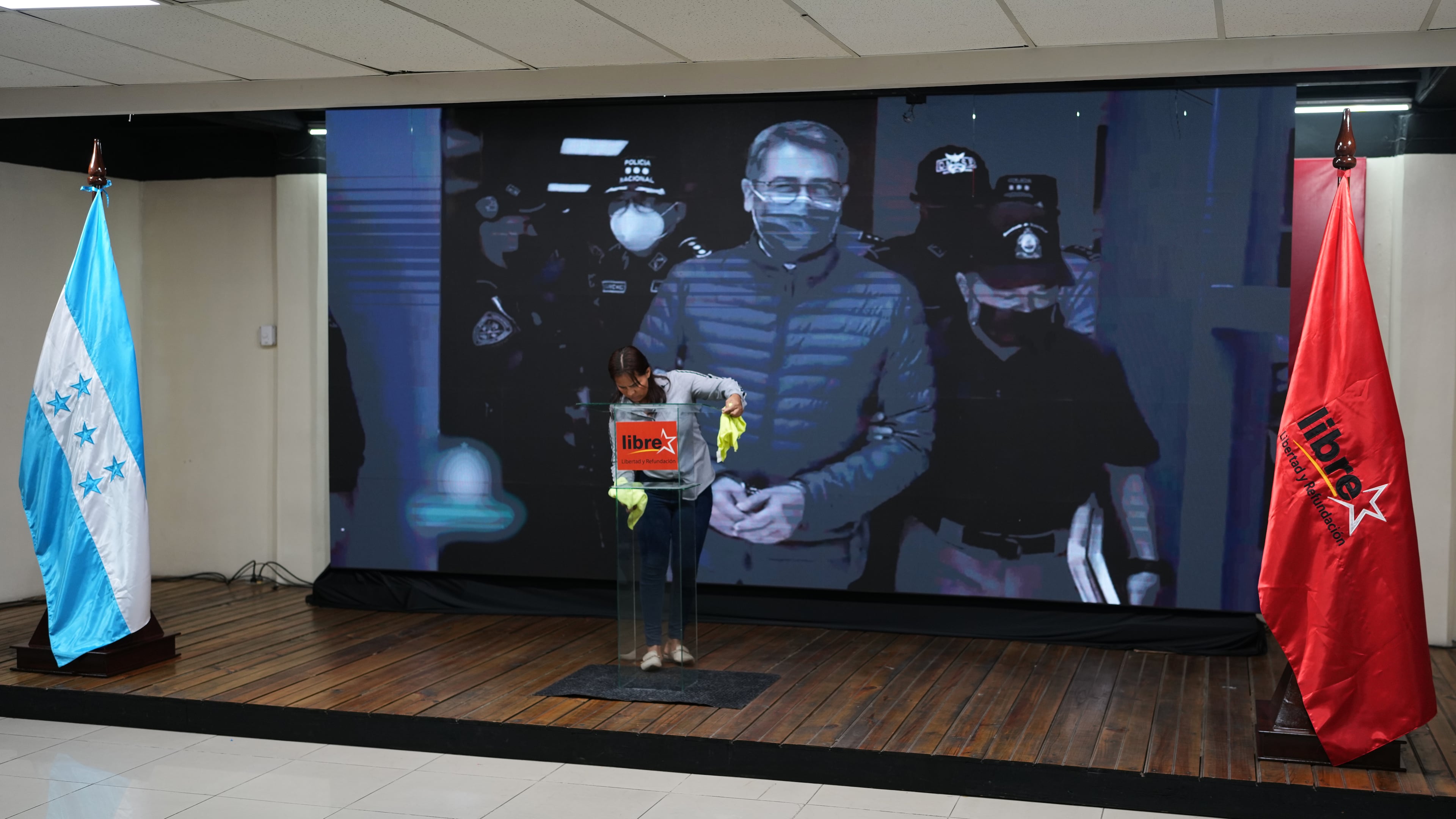 A screen displays an image of former Honduran President Juan Orlando Hernandez, a day after President Donald Trump said he plans to pardon Hernandez for a 2024 drug trafficking sentence, before the start of a press conference of Ruling party presidential candidate Rixi Moncada in Tegucigalpa, Honduras, Saturday, Nov. 29, 2025. (AP Photo/Moises Castillo)