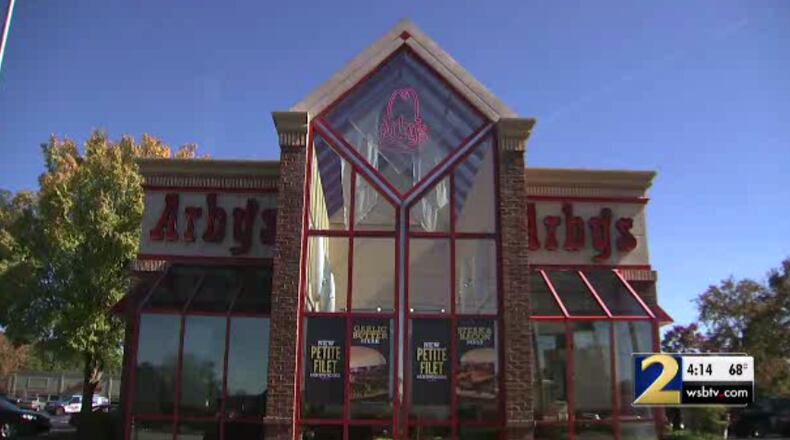 An Arby's employee clung to the hood of a car in an attempt to chase two men who paid with counterfeit money, police said.