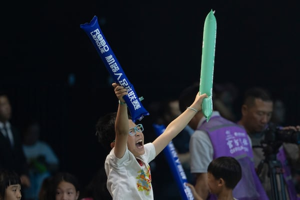 A child reacts as he watches the inaugural RoBoLeague robot soccer competition in Beijing, Saturday, June 28, 2025. (AP Photo/Ng Han Guan)