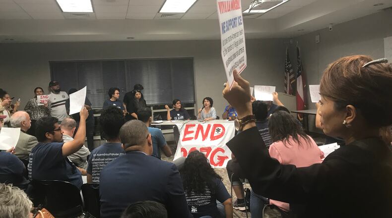 Supporters and opponents of the federal 287(g) immigration enforcement program attended a panel discussion held Wednesday night at the Collins Hill branch of the Gwinnett County Public Library. TYLER ESTEP / TYLER.ESTEP@AJC.COM
