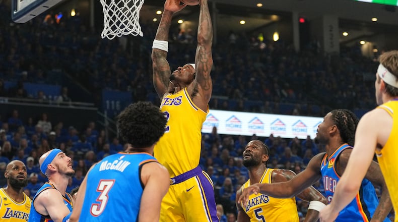Los Angeles Lakers forward Jarred Vanderbilt, center, goes up for a shot as Oklahoma City Thunder's Jared McCain (3) and Alex Caruso, second from left, defend in the first half of Game 1 in a second-round NBA basketball playoffs series Tuesday, May 5, 2026 in Oklahoma City. (AP Photo/Kyle Phillips)
