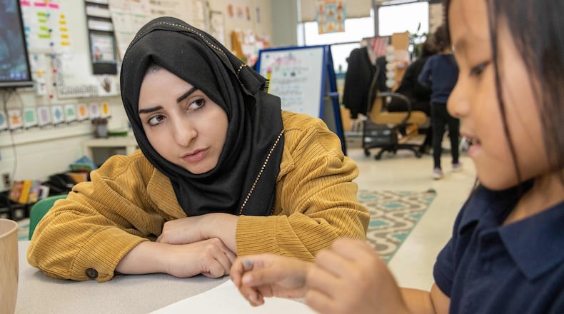 Shaikila Amiaq (left), a recent Afghan refugee who is studying to become a teacher, helps Ritu Gurung in Taylor Thomas' kindergarten class at the International Community School in Clarkston. PHIL SKINNER FOR THE ATLANTA JOURNAL-CONSTITUTION