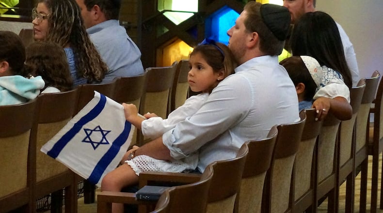 FILE - A family with Israel flags attends Shabbat services at Temple Beth Sholom in Miami Beach, Fla., Oct. 13, 2023. (AP Photo/Giovanna Dell'Orto, File)
