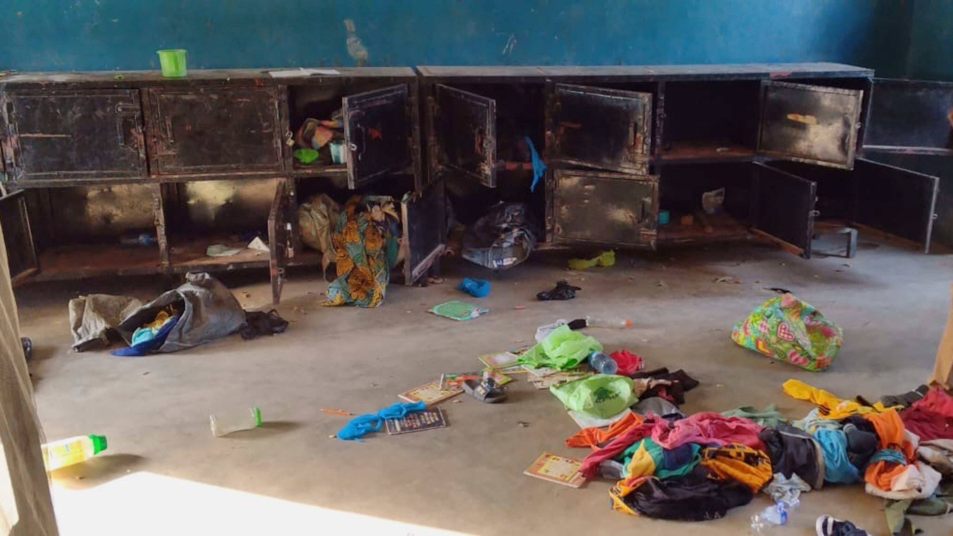 In this photo released by Christian Association of Nigeria, a man walk past belongings at the St. Mary's Catholic Primary and Secondary School after gunmen abducted children and staff in Papiri community, Nigeria, Friday, Nov. 21, 2025. (Christian Association of Nigeria via AP)